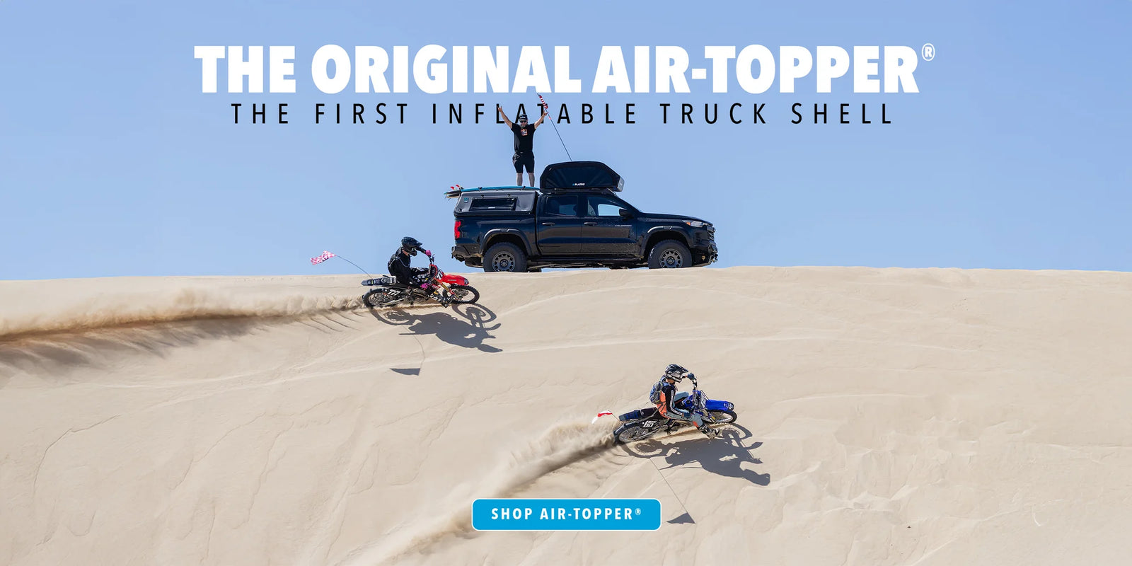 Two people on dirt bikes in sand dunes and ute with inflatable canopy and words 'The Original Air-Topper'.